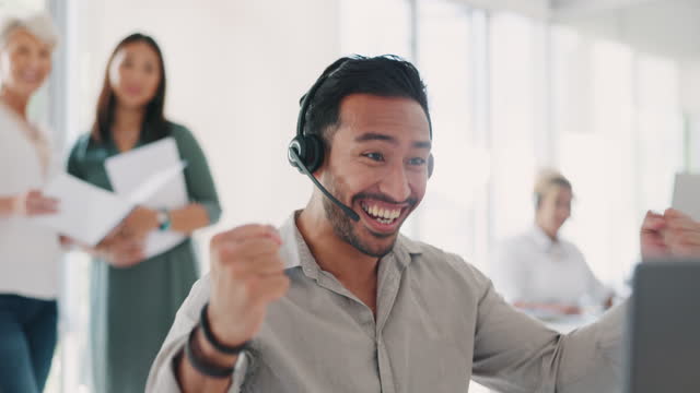 Applause, success and man celebrate at call center for target, bonus and sale with employees for congratulations on win. Contact us, CRM and telemarketing customer support men and women at computer