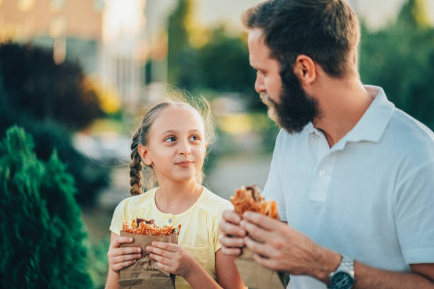 istock Father with daughter eating fast food 1461435643