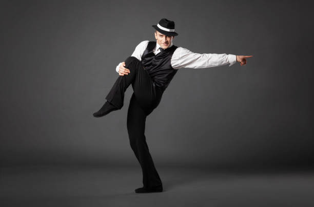 confident young man dancing in gangster style suite. - men 20s cut out 30s imagens e fotografias de stock