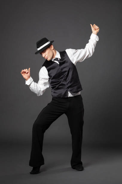 confident young man dancing in gangster style suite. - men 20s cut out 30s imagens e fotografias de stock