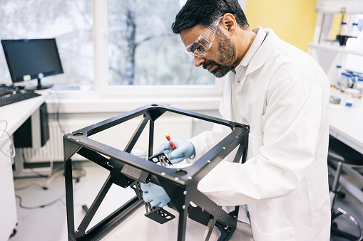 The prototype on the table in front of the scientist appears to be in the final stages of development.