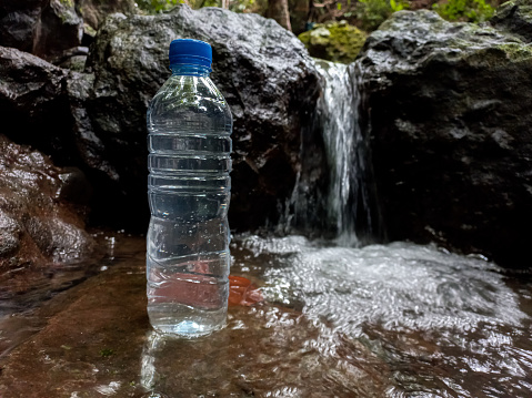 Bottle mineral water on rocks in the river.