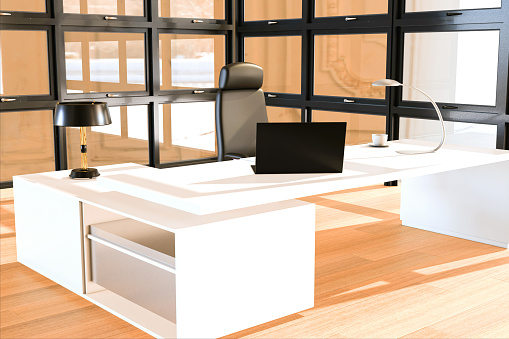 Illuminated office interior with a laptop, large windows and a decorative lamp. Design and interior decoration. 3d rendering.