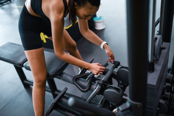istock Female Athlete Preparing Row Machine In Gym For Exercising 1461440642