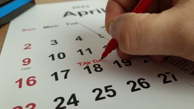 Tax payment day marked on a calendar - April 18, 2023 with 1040 form