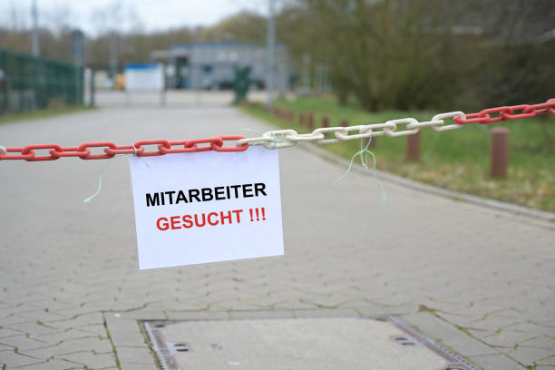 Sign at the entrance of a company with German text “Mitarbeiter gesucht”, meaning “Employees wanted”, concept for increasing shortage of workers due to demographic change, copy space Sign at the entrance of a company with German text “Mitarbeiter gesucht”, meaning “Employees wanted”, concept for increasing shortage of workers due to demographic change, copy space, selected focus teamwork slogan stock pictures, royalty-free photos & images