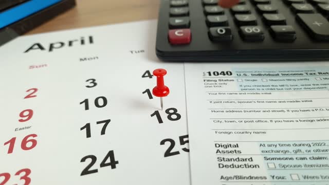 Tax payment day marked on a calendar - April 18, 2023 with 1040 form