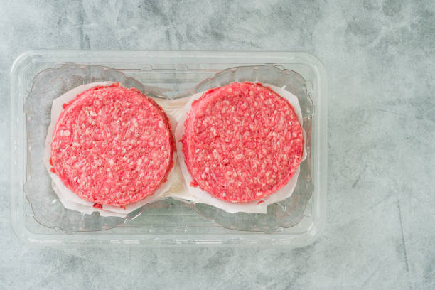 istock Burger patties in plastic container close-up. Fresh raw burger patties close-up on a grey stone background 1461449113