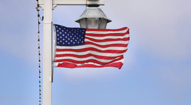 drapeau des états-unis d’amérique flottant sur un poteau de lanterne - voting usa pole flag photos et images de collection