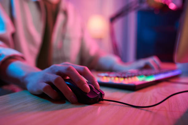 Gamer Playing Videogame Hand of teenage boy using keyboard and mouse when playing videogame at home neon bedroom stock pictures, royalty-free photos & images