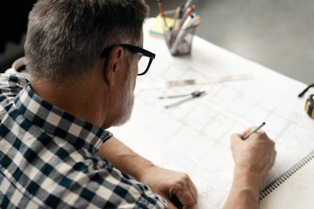istock Mature Architect Engineer Design Working Planning Concept. Portrait of businessman working on blueprints at the office 1461457844