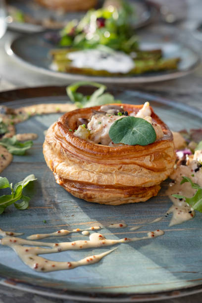 chicken and mushroom vol-au-vent on a styled ceramic plate, delicious hot dish with hollow shells of puff pasty and creamy filling - vol au vent imagens e fotografias de stock