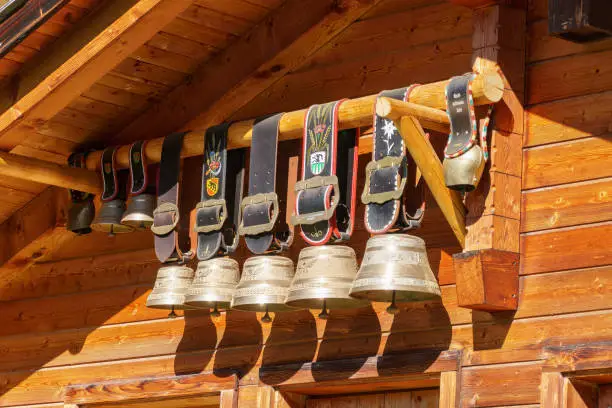 A row of oversized traditional cowbell decorations adorn a wooden house in Switzerland