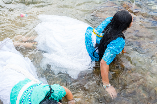 Salvador, Bahia, Brazil - February 02, 2017: Two Candomble women are seen bathing in the sea during the religious festival of Iemanja in Salvador, Bahia.