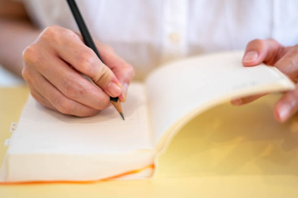 istock Females hand making notes with pencils and empty notebooks in their room. 1461470447