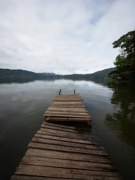 Photo of Idyllic Amazon rainforest jungle river lake landscape with broken damaged wooden jetty dock pier in Peru South America