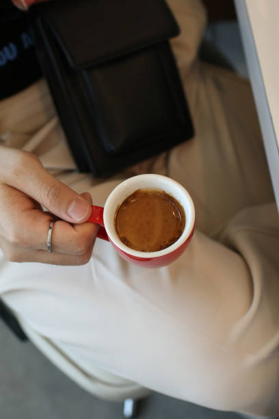 istock Hand man holding hot coffee espresso in red cup on white table with copy space. Morning cup of coffee. 1461471417