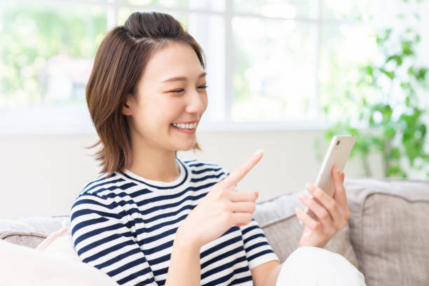 attractive Asian woman using a smart phone stock photo