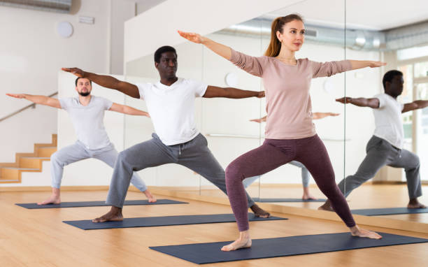 istock People exercising warrior two asana in gym 1461472834