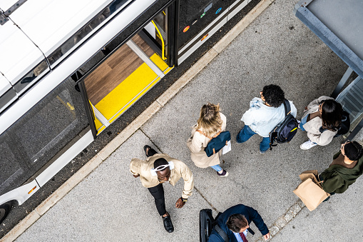 People crowd waiting for city commuter bus at transport stop, top view