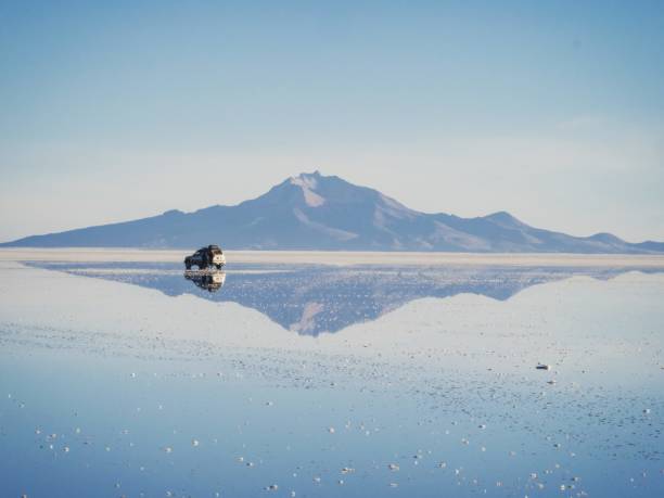 geländewagen suv jeep der reisegruppe auf dem salzsee salar de uyuni in bolivien anden sonnenaufgang spiegelreflexion - salar stock-fotos und bilder
