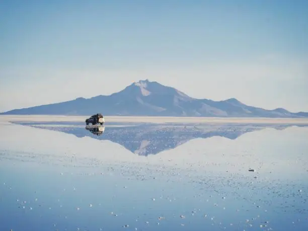 Andes mountains sunrise panorama mirror reflection on Salar de Uyuni salt flat lake in Potosi Bolivia, South America