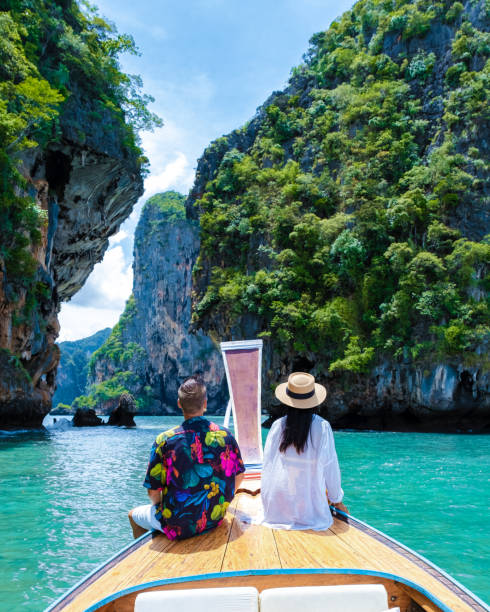 Longtail boat in Krabi Thailand, couple man, and woman on a trip at the tropical island 4 Island Luxury Longtail boat in Krabi Thailand, couple man, and woman on a trip to the tropical island 4 Island trip in Krabi Thailand. Asian woman and European man mid age on vacation in Thailand. krabi province stock pictures, royalty-free photos & images