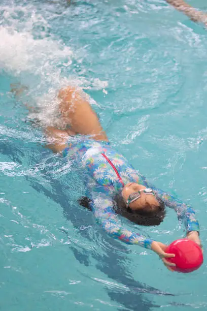 Photo of Girl swimming with the help of a ball