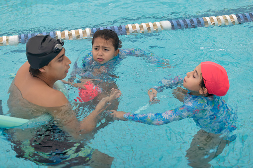Swimming instructor giving directions to a young girl