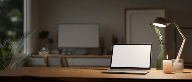 istock Minimal workspace with laptop mockup, candles, table lamp, and copy space on wood table 1461495852