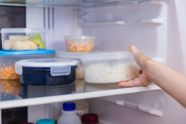 istock Asian woman stored leftovers food in plastic container put into refrigerator. 1461501873
