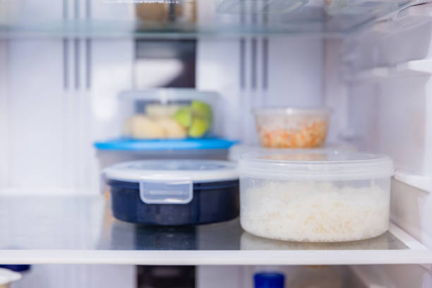 istock Asian woman stored leftovers food in plastic container put into refrigerator. 1461501888