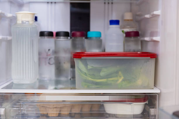 istock Asian woman stored leftovers food in plastic container put into refrigerator. 1461501896