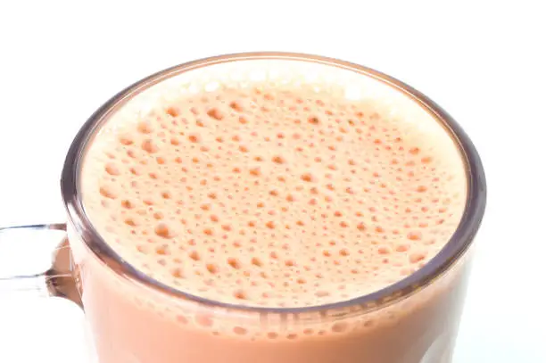 Photo of Selective focus with noise effect of milk tea or popularly known as Teh Tarik in Malaysia over white background.