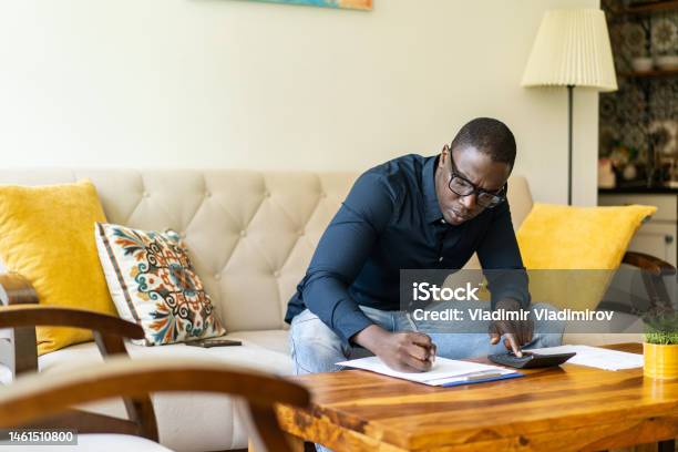 A Worried Man Is Adding Up His Household Expenses Stock Photo - Download Image Now - Price, Comparison, Consumerism