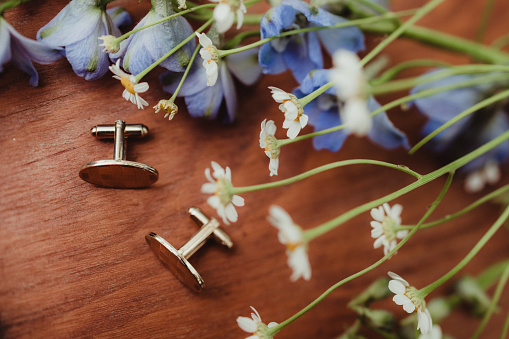 Photo from above of cuff links and flowers