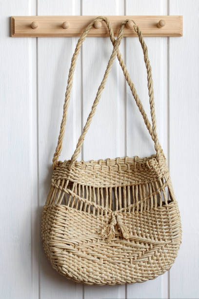 istock wicker summer bag hangs on a wooden hanger on a white wall. 1461519700