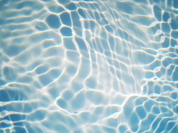 istock Defocus blurred transparent blue colored clear calm water surface texture with splashes and bubbles. Trendy abstract nature background. Water waves in sunlight with caustics. Blue water shinning 1461526795