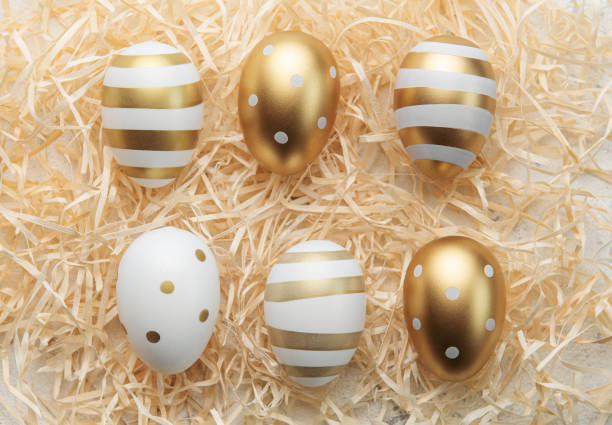 istock Easter eggs painted with gold paint on a straw background 1461533546