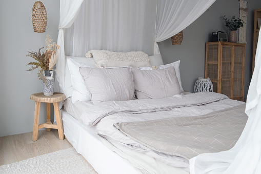 Bright Scandi-style interior in the bedroom. A linen bed or bedding. Close up interior details photo. High quality