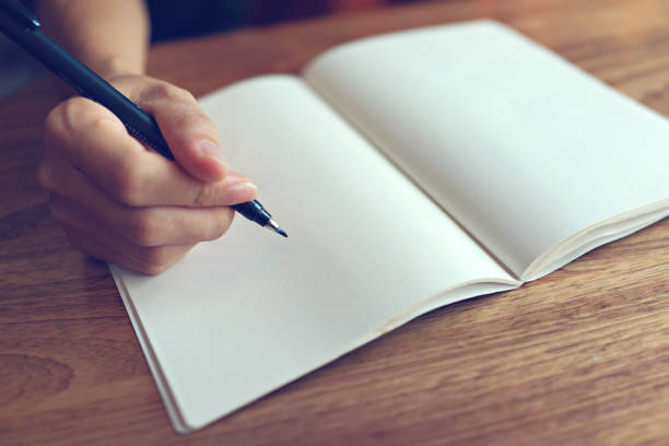 istock Close up woman hand writing on a blank notebook. 1461537127