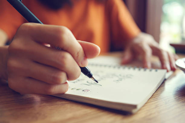 istock Close up woman hand writing motivational quote on notebook. 1461537143