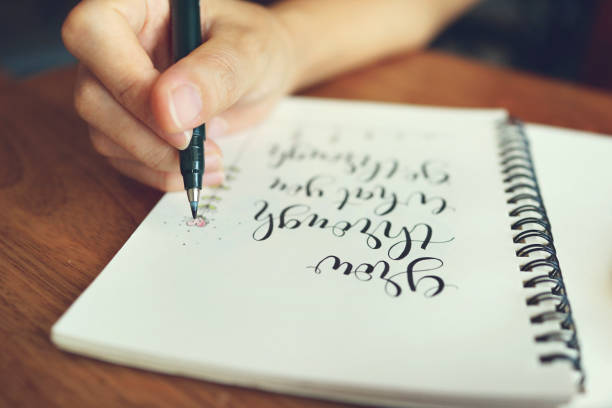 istock Close up woman hand writing motivational quote on notebook. 1461537151