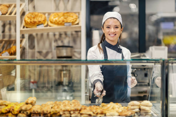 istock A bakery worker is selling pastry and bread at the supermarket while smiling at the camera. 1461539632