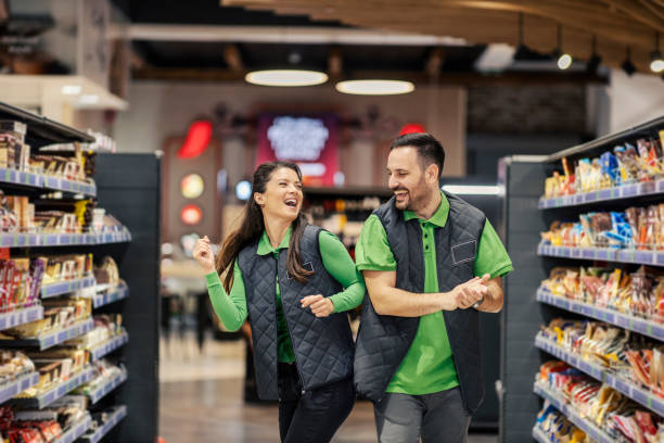 Joyful supermarket workers are dancing at marketplace. stock photo