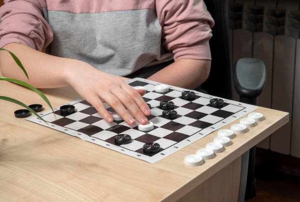 istock The process of playing the board game of checkers. 1461542231