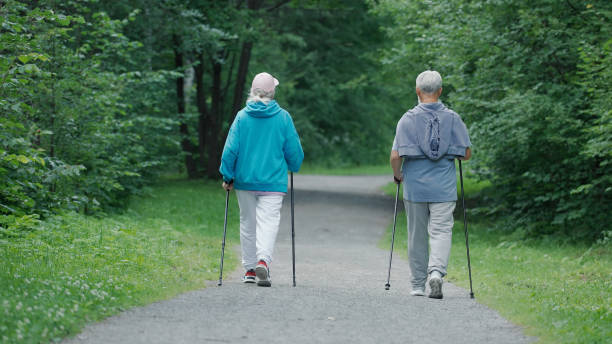 istock Elderly german people going forward in forest park. Old grandparents nordic walk 1461544996