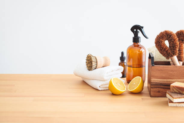 Zero waste eco products and tools for kitchen cleaning. Wooden brushes, coconut sponges, spray vinegar, lemon and organic soap, gray background.