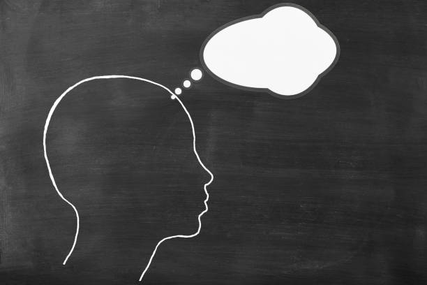 Chalk drawn human head shape with blank thought bubble on blackboard with copy space.