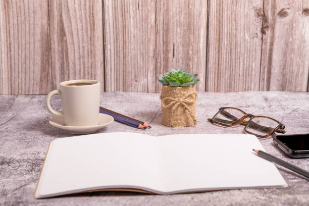 notebook with blank pages, glasses and coffee mug with space for text